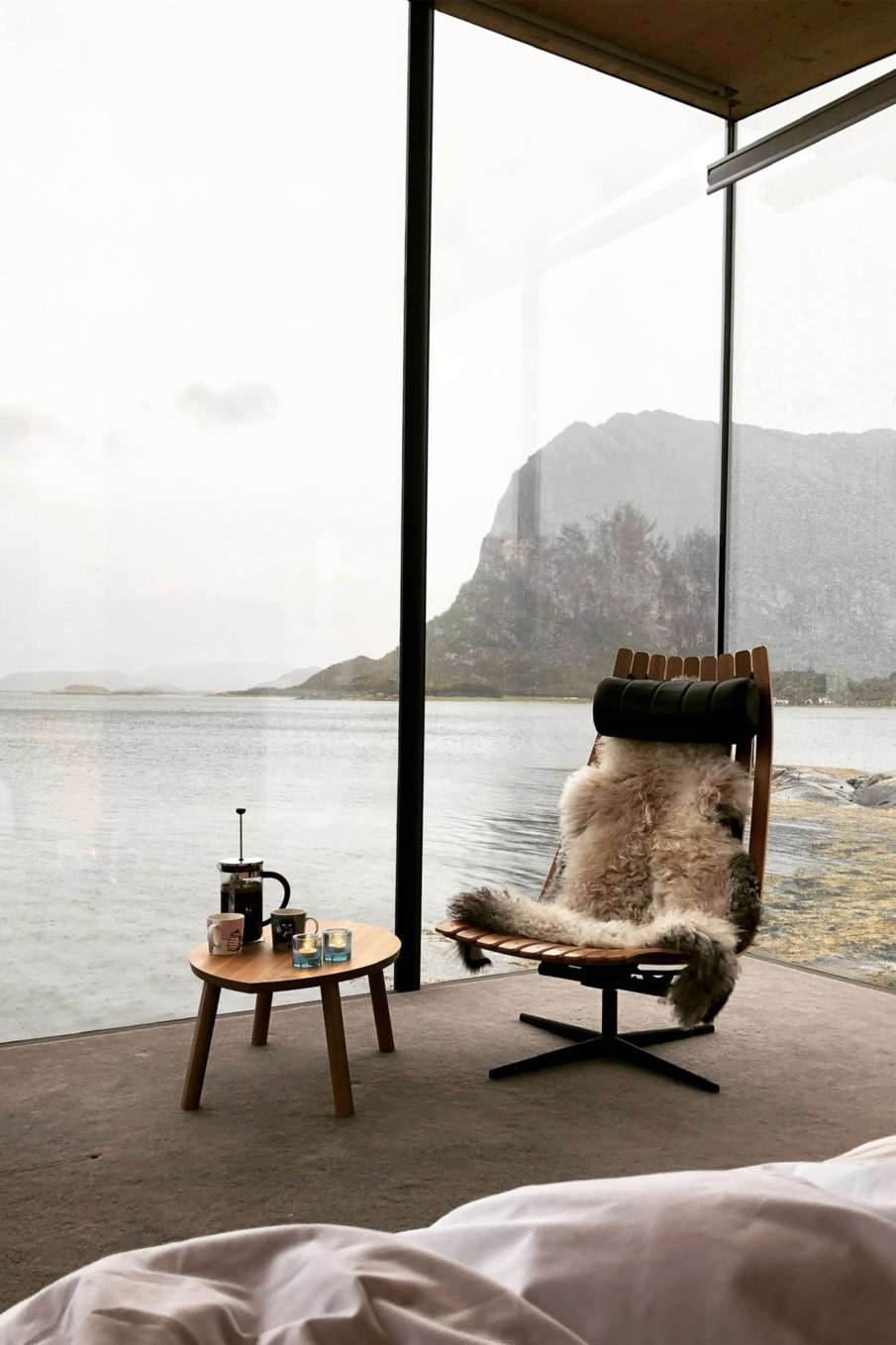 An area for morning coffee, surrounded by large windows showcasing the view of the nature outside.