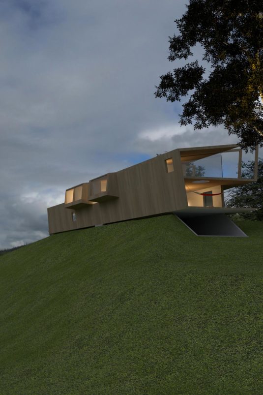 At the top of a grass-covered mound rests a modern, brightly lit building.